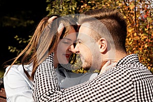 Romantic couple in the autumn park - love, relationship and dating concept