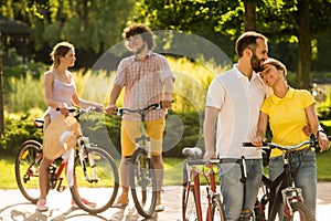 Romantic couple of bicyclists is hugging outdoors.