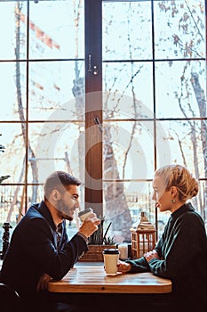 Romantic couple in the cafe is drinking coffee and talking.