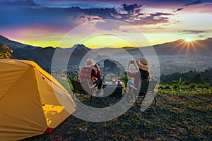 Romantic couple camping outdoors and taking photos with camera while camping at sunrise. Phu Lang Ka, Pha yao province in Thailand photo