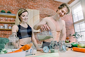 Romantic couple is cooking on kitchen. Handsome man and attractive young woman are having fun together while making