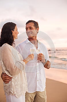 Romantic Couple Drinking Champagne on the Beach at Sunset