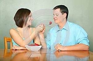 Romantic Couple Eating Fruits On Kitchen Table