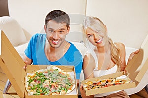 Romantic couple eating pizza at home