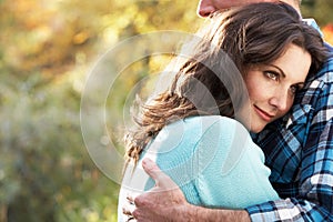 Romantic Couple Embracing By Autumn Woodland photo