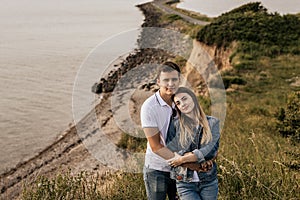 Romantic couple in embrance stand on the beach with mountains