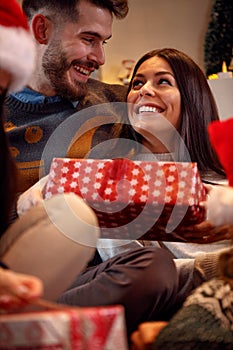 Romantic couple exchanging gift boxes at Christmas eve