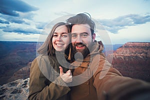 Romantic couple or friends show thumbs up and make selfie photo on travel hiking at Grand Canyon in Arizona