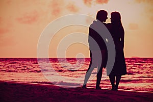 Romantic couple holding hands at sunset beach