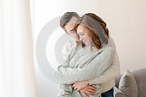Romantic couple hugging and kissing at home during weekend