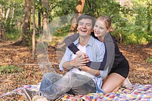 Romantic couple hugging and laughing together while looking something at outdoors. Cheerful woman blond hair embracing her