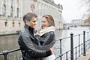 Romantic Couple In Jackets Embracing By Railing