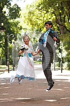 Romantic couple jumping and smiling on background park