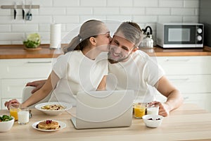 Romantic couple kiss enjoying delicious healthy breakfast at hom