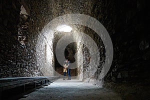 Romantic couple kissing on a dark ruin antique temple arab muslim church tunnel room with a hole where light comes through