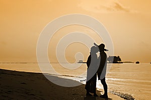 Romantic couple kissing and holding hands on beach