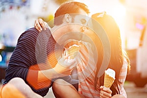 Romantic couple kissing while holding ice cream