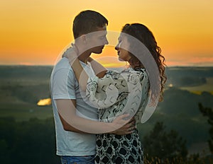 Romantic couple looking at each other at sunset on outdoor, beautiful landscape and bright yellow sky, love tenderness concept, yo