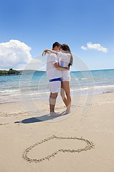 Romantic couple in love have fun on the beach with heart drawi