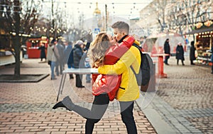 Romantic couple in love kissing, hugging, walking on the street, wearning in bright down jackets. urban background.