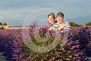 Romantic couple in love in lavender fields in Provence, France. Beautiful young man and woman hugging at sunset. Wedding