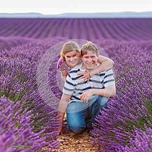 Romantic couple in love in lavender fields in Provence, France. Beautiful young man and woman hugging at sunset. Wedding