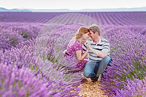 Romantic couple in love in lavender fields in Provence, France. Beautiful young man and woman hugging at sunset. Wedding