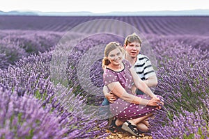 Romantic couple in love in lavender fields in Provence, France. Beautiful young man and woman hugging at sunset. Wedding