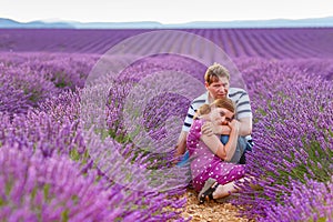 Romantic couple in love in lavender fields in Provence, France. Beautiful young man and woman hugging at sunset. Wedding