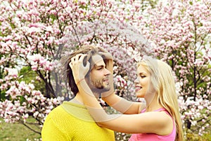 Romantic couple in love in spring garden at blooming magnolia