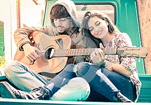 Romantic couple of lovers playing guitar on vintage minicar