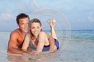 Romantic Couple Lying In Sea On Tropical Beach Holiday