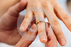 Romantic couple making love promise with ring to each other at home