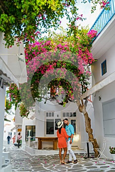 Romantic couple of men and women at the street of Mykonos Greek village in Greece