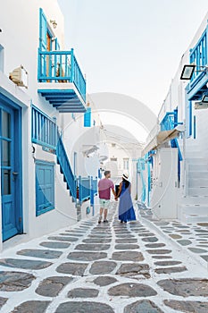 Romantic couple of men and women at the street of Mykonos Greek village in Greece