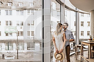 Romantic couple near panoramic windows in restorant