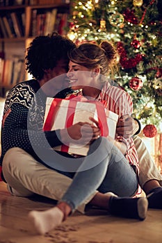 Romantic couple opening a present on a Christmas