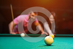 Romantic couple playing billiard in dark club