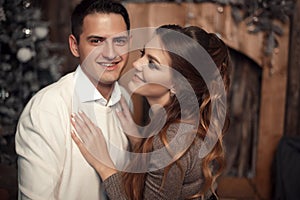 Romantic couple portrait in love. Cheerful Happy newlywed hugging in cozy wooden interior on winter holidays.