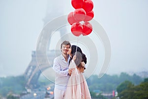 Romantic couple with red balloons together in Paris