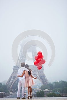 Romantic couple with red balloons together in Paris