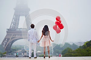 Romantic couple with red balloons together in Paris