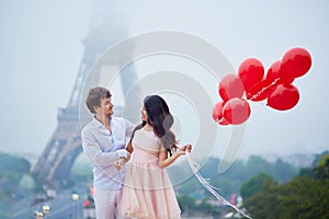 Romantic couple with red balloons together in Paris