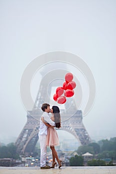 Romantic couple with red balloons together in Paris