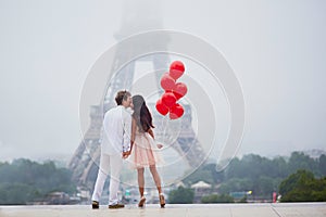 Romantic couple with red balloons together in Paris