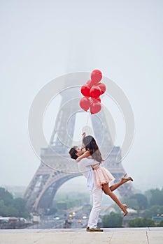 Romantic couple with red balloons together in Paris