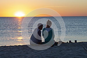 Romantic couple relaxes on a beach, drinks coffee