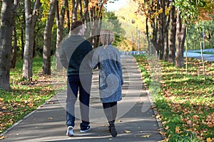 Romantic couple relaxing in autumn park, cuddling, enjoying fresh air, beautiful nature, nice fall weather. Beloved