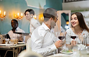 Romantic couple at restaurant having dinner and drinking wine at restaurant