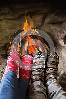Romantic couple's legs in socks in front of fireplace